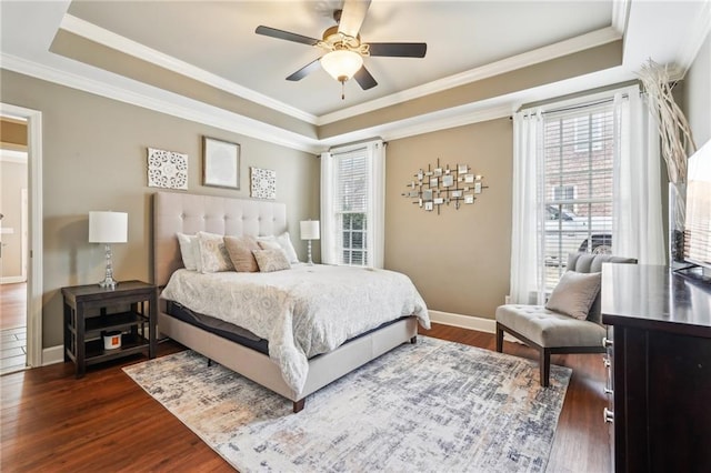 bedroom with a tray ceiling and dark wood-style floors