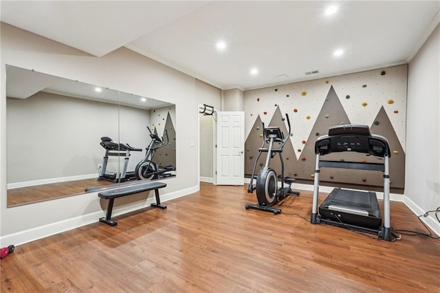 exercise room with visible vents, baseboards, ornamental molding, recessed lighting, and wood finished floors