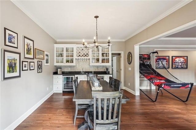 dining area featuring baseboards, ornamental molding, dark wood-type flooring, wine cooler, and a chandelier