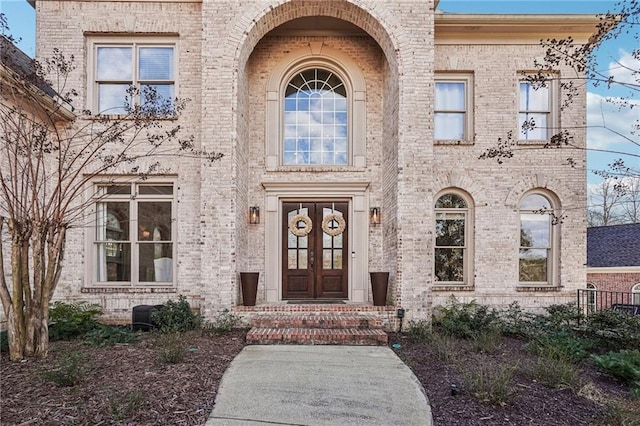 entrance to property featuring brick siding and french doors