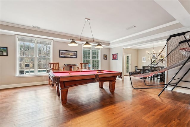 rec room featuring a raised ceiling, wood finished floors, and a healthy amount of sunlight