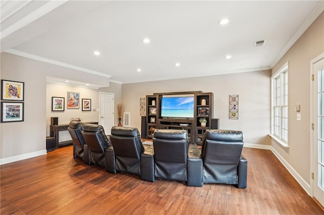 cinema featuring visible vents, crown molding, baseboards, and wood finished floors