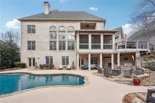 rear view of property featuring french doors, outdoor lounge area, a sunroom, an outdoor pool, and a patio area