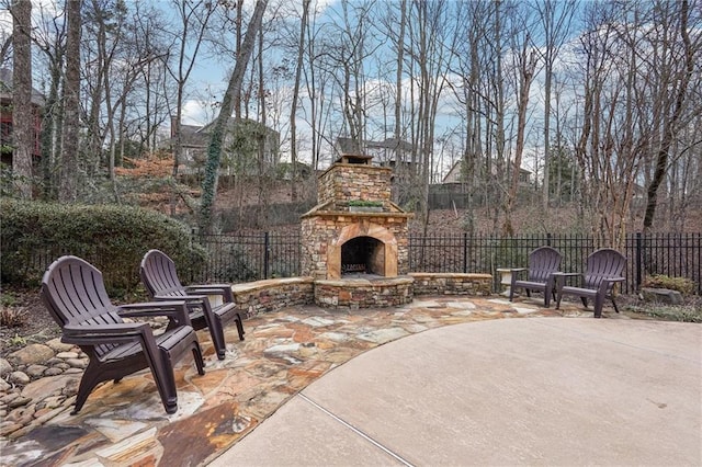 view of patio featuring an outdoor stone fireplace and fence