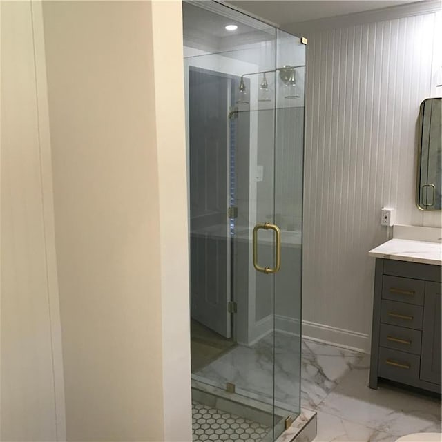 full bathroom with marble finish floor, baseboards, vanity, and a shower stall