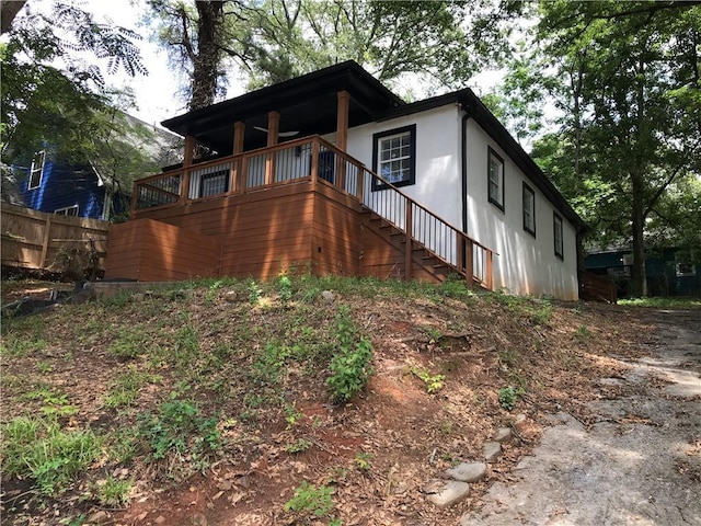 view of property exterior featuring fence and stairway