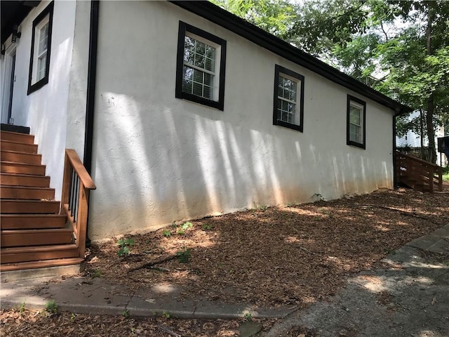 view of property exterior featuring stairway and stucco siding