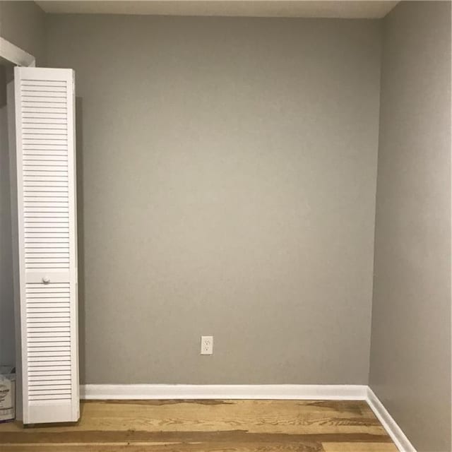 unfurnished bedroom with wood finished floors and baseboards