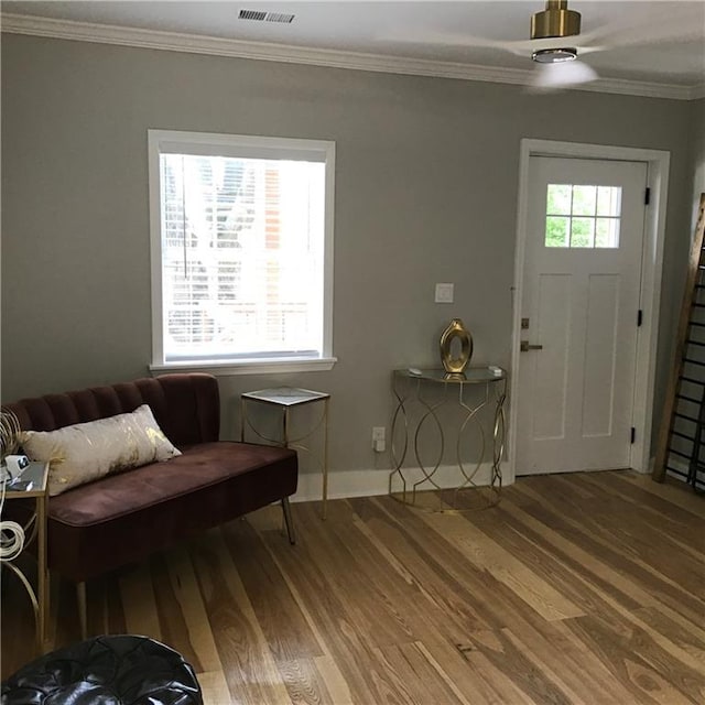 foyer entrance with wood finished floors, a wealth of natural light, and crown molding