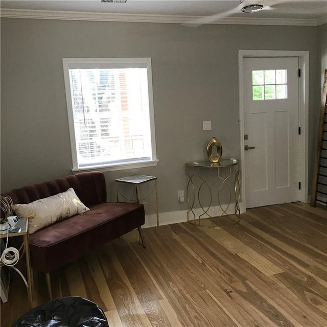 entrance foyer featuring plenty of natural light, ornamental molding, and wood finished floors