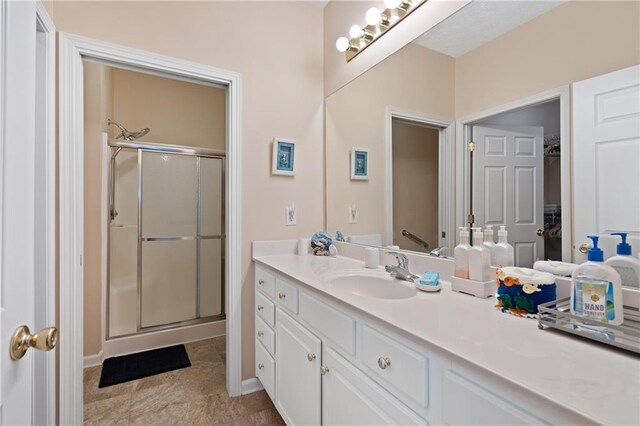 3734 Villa Springs Cir, Powder Springs, GA 30127 - full bath featuring a stall shower, vanity, a walk in closet, and baseboards