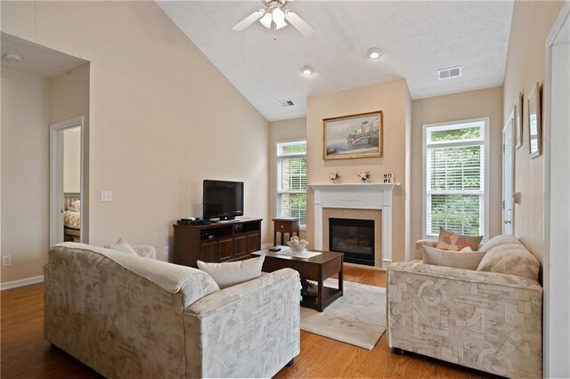 3734 Villa Springs Cir, Powder Springs, GA 30127 - living room featuring wood finished floors, lofted ceiling, a glass covered fireplace, ceiling fan, and baseboards
