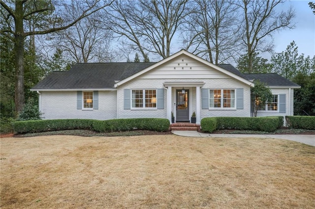 ranch-style house featuring brick siding and a front yard