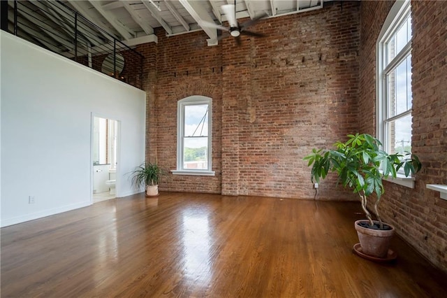1596 Cleveland Ave Unit 301, East Point, GA 30344 - spare room featuring brick wall, a high ceiling, a ceiling fan, beamed ceiling, and wood finished floors