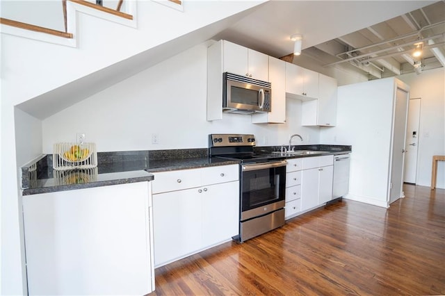 1596 Cleveland Ave Unit 301, East Point, GA 30344 - kitchen with appliances with stainless steel finishes, dark wood-type flooring, white cabinetry, and beamed ceiling