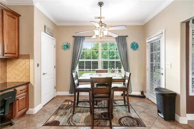 dining area with light tile patterned floors, baseboards, visible vents, a ceiling fan, and ornamental molding