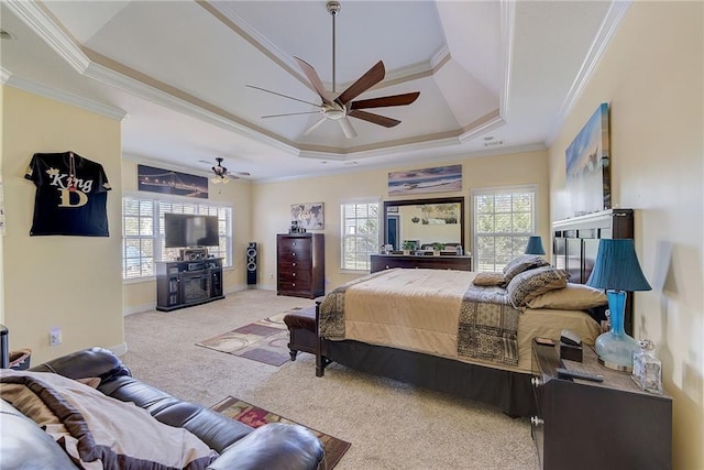 carpeted bedroom featuring a raised ceiling, crown molding, baseboards, and ceiling fan