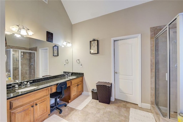 bathroom featuring vaulted ceiling, double vanity, a sink, and a shower stall