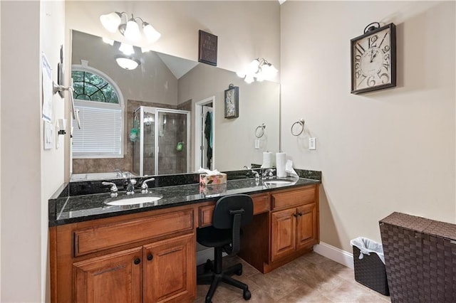 bathroom with double vanity, a shower stall, a sink, and lofted ceiling