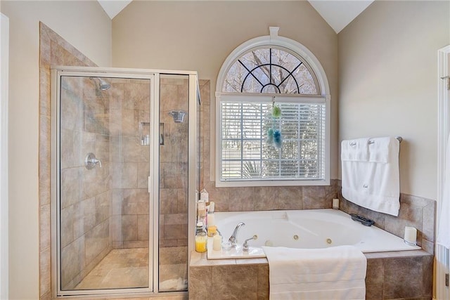 bathroom with a stall shower, lofted ceiling, and a tub with jets