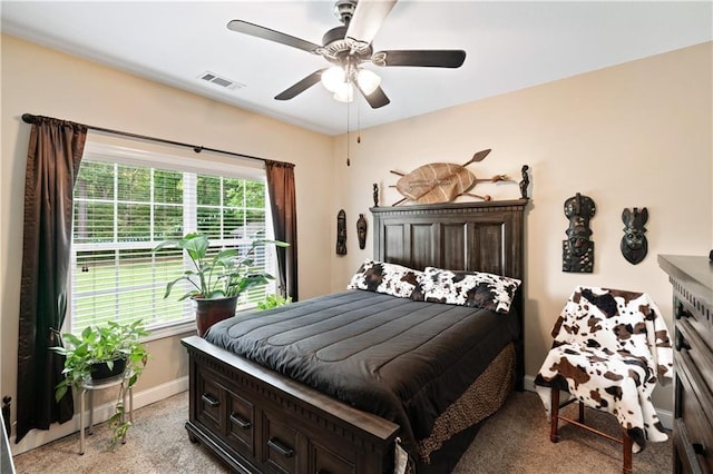 bedroom with light carpet, ceiling fan, visible vents, and baseboards