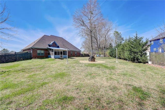 view of yard with a sunroom and fence