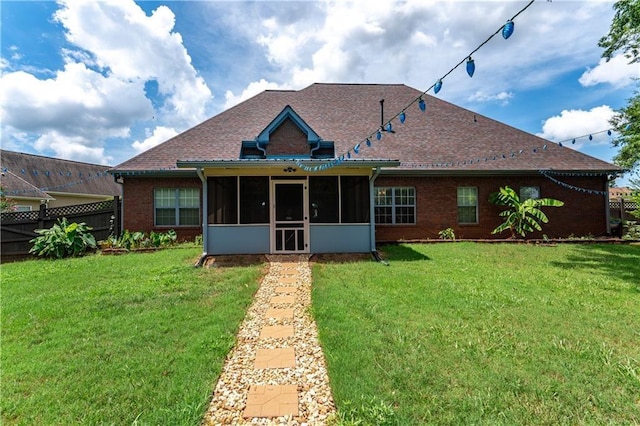 back of house with roof with shingles, a lawn, fence, and a sunroom