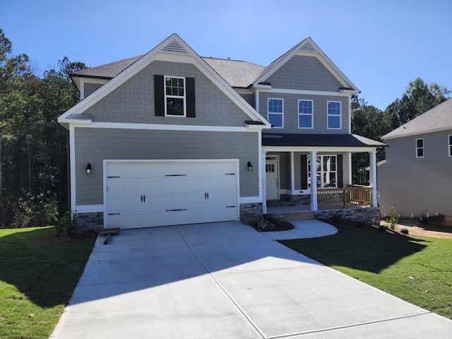 craftsman inspired home featuring covered porch, a garage, and a front lawn