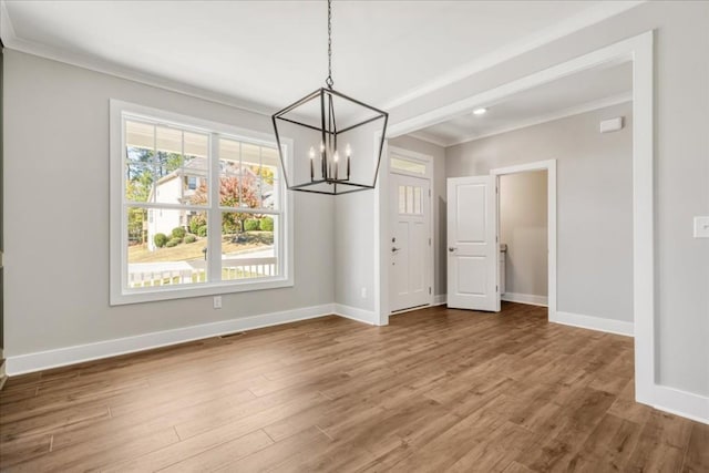 unfurnished dining area with crown molding and hardwood / wood-style flooring