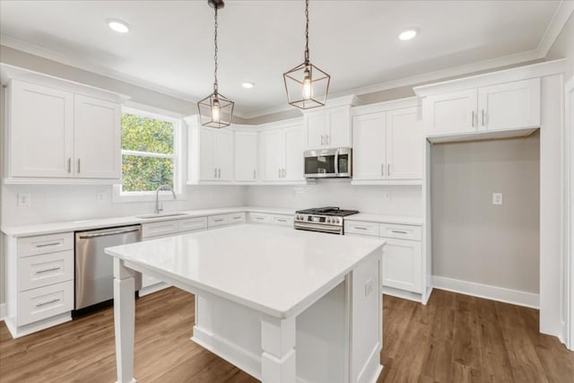 kitchen with stainless steel appliances, dark wood-type flooring, pendant lighting, white cabinets, and a center island