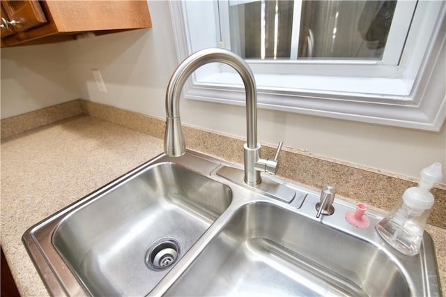 interior details featuring brown cabinetry, light countertops, and a sink