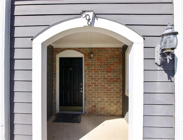 entrance to property featuring brick siding