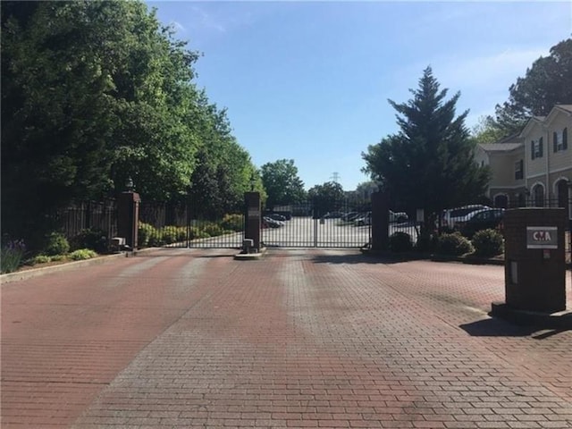 view of road featuring curbs, a gated entry, and a gate