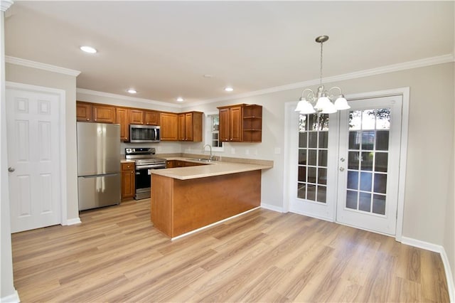 kitchen featuring open shelves, light countertops, hanging light fixtures, appliances with stainless steel finishes, and a peninsula