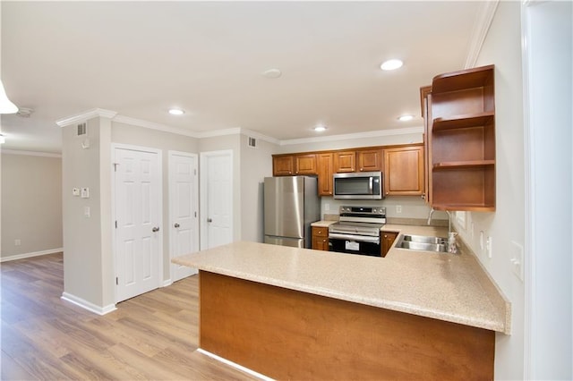 kitchen featuring appliances with stainless steel finishes, a peninsula, light countertops, open shelves, and a sink