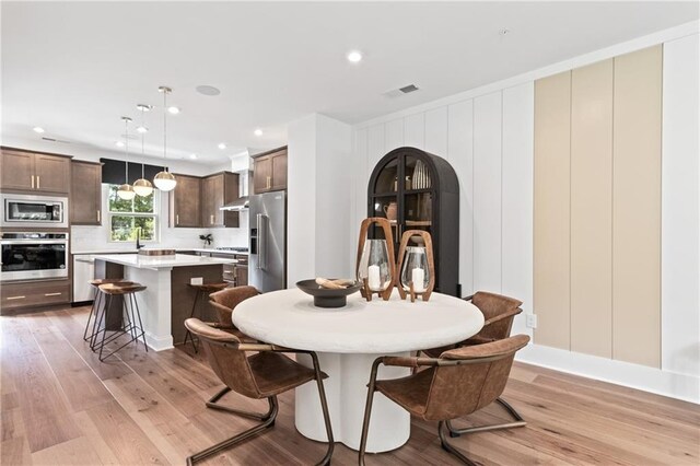 dining space with recessed lighting, visible vents, and light wood-style flooring