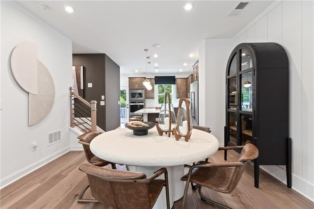 dining room with light wood-type flooring, visible vents, recessed lighting, and stairway