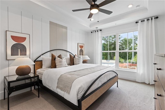 bedroom featuring a raised ceiling, recessed lighting, and light colored carpet