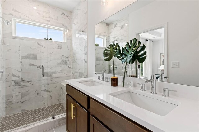 bathroom featuring double vanity, a stall shower, and a sink