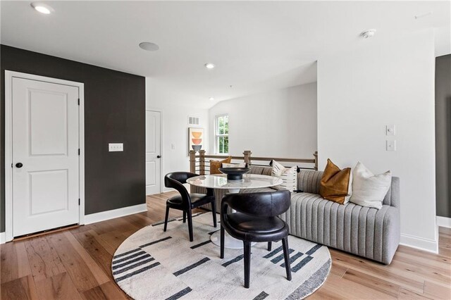 dining space featuring visible vents, light wood-style flooring, recessed lighting, baseboards, and vaulted ceiling