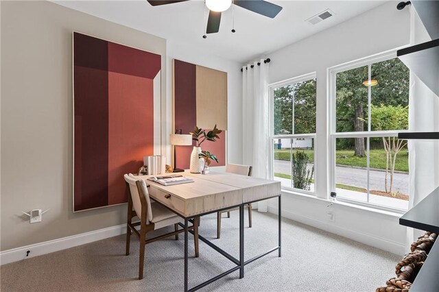 office area with visible vents, baseboards, light colored carpet, and a ceiling fan