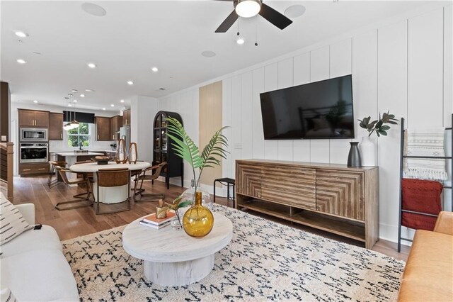 living room featuring recessed lighting, baseboards, ceiling fan, and wood finished floors