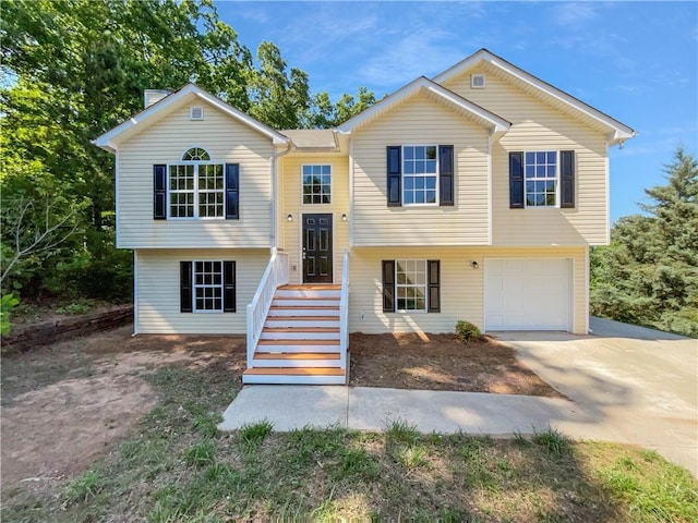 bi-level home with an attached garage and concrete driveway