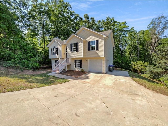 raised ranch featuring a garage and concrete driveway