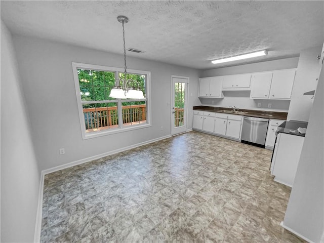 kitchen with a sink, dark countertops, white cabinets, and stainless steel dishwasher