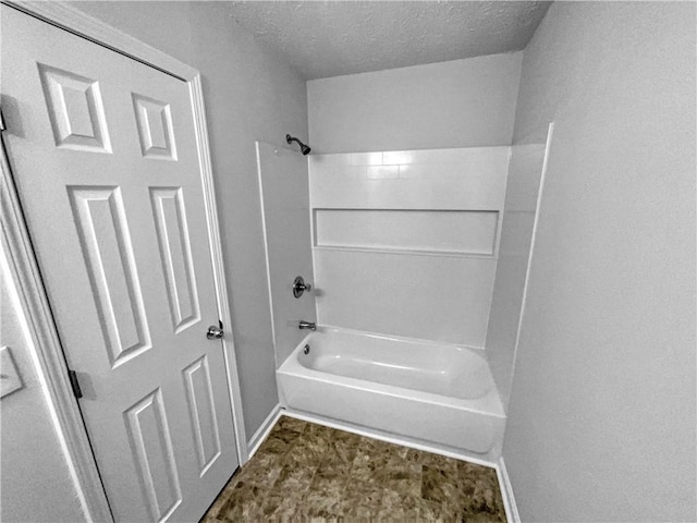 full bath featuring shower / bath combination, baseboards, and a textured ceiling