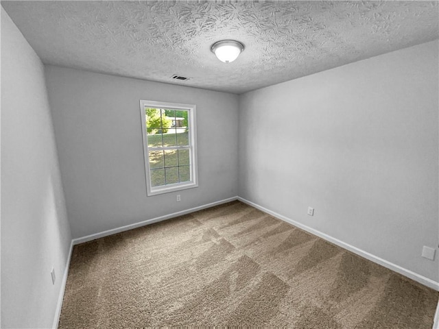 carpeted empty room with baseboards, a textured ceiling, and visible vents
