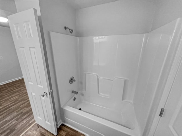 full bath featuring shower / bath combination, baseboards, and wood finished floors