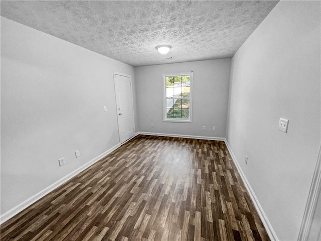 empty room featuring baseboards and dark wood-style flooring