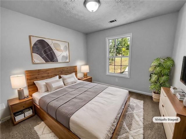 carpeted bedroom with a textured ceiling, baseboards, and visible vents